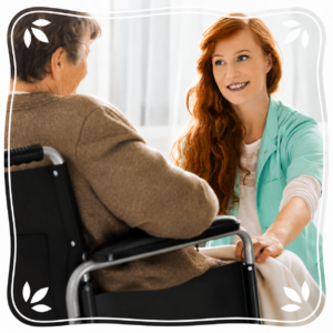 A younger woman greeting an older woman who uses a wheelchair